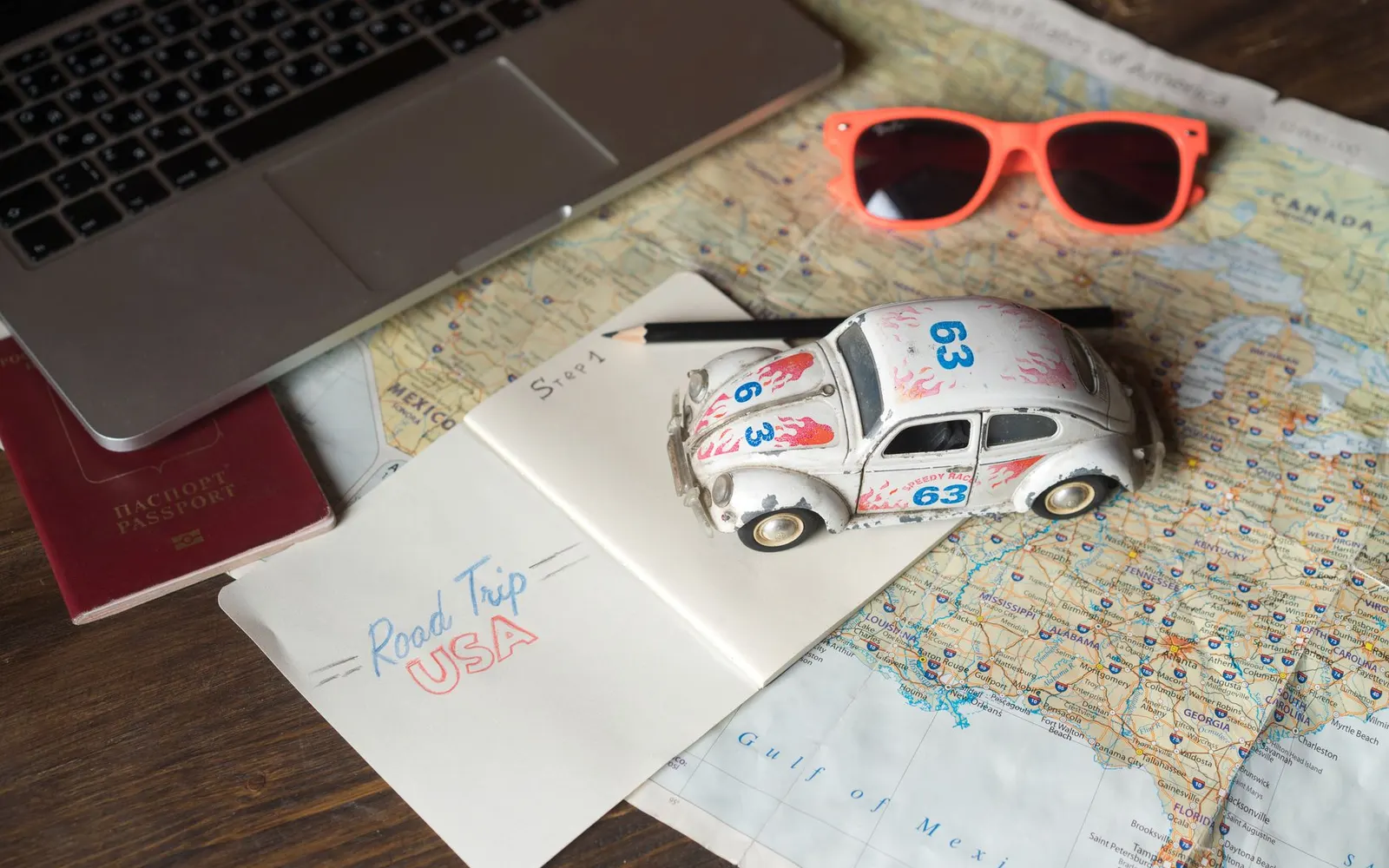 Bureau avec ordinateur, carte et carnet pour organiser un voyage