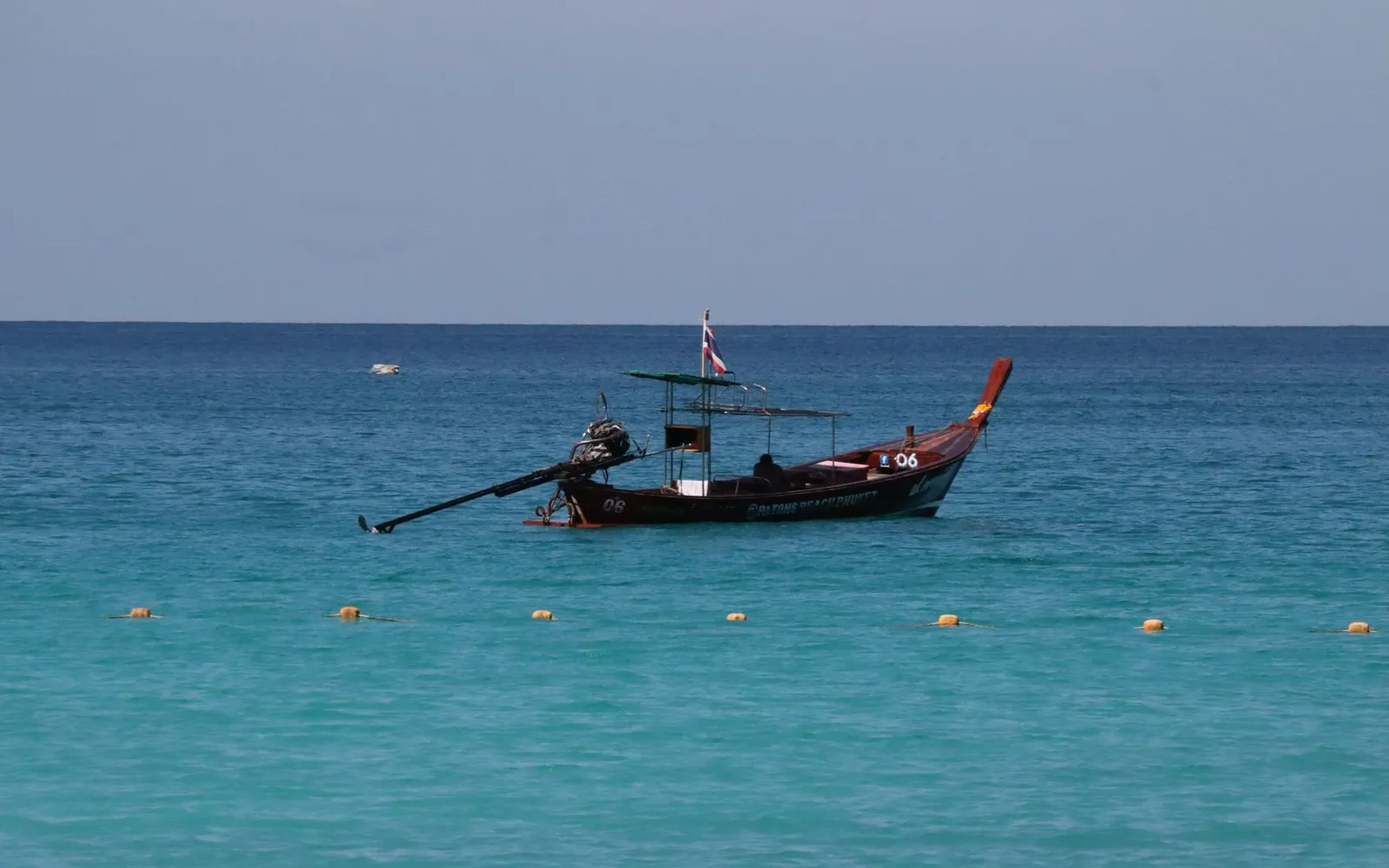 Temple thaïlandais et longue-queue sur une plage de Thaïlande